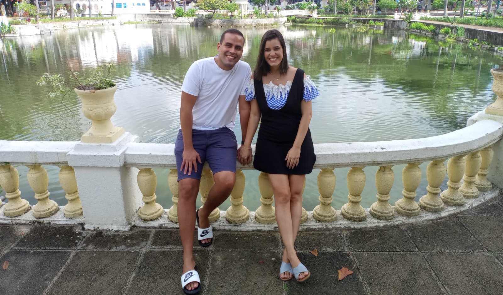 casal posa para a foto em frente à lagoa da Cidade da Criança